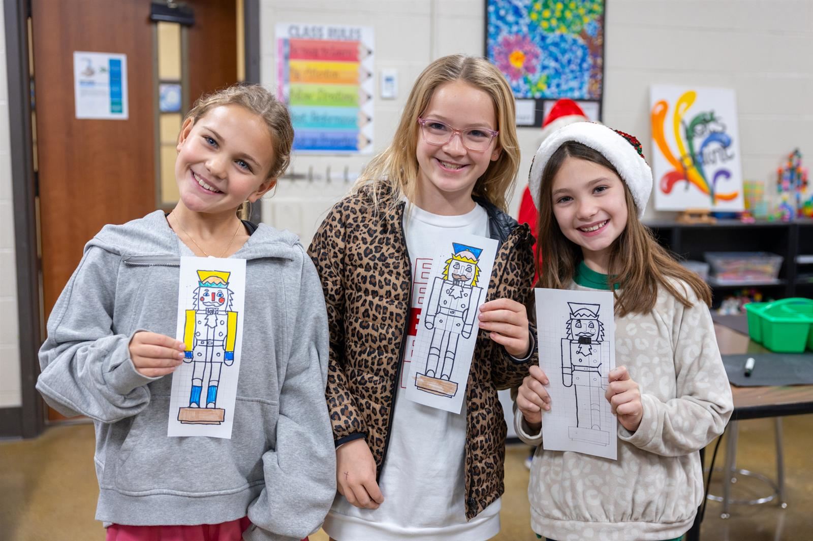 Three girls showing their nutcracker artwork